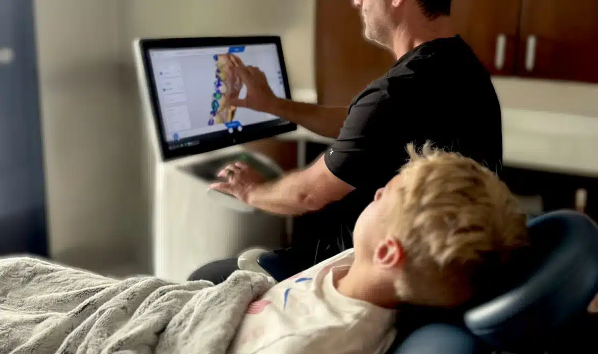 dentist going over xray results on a monitor with a young patient