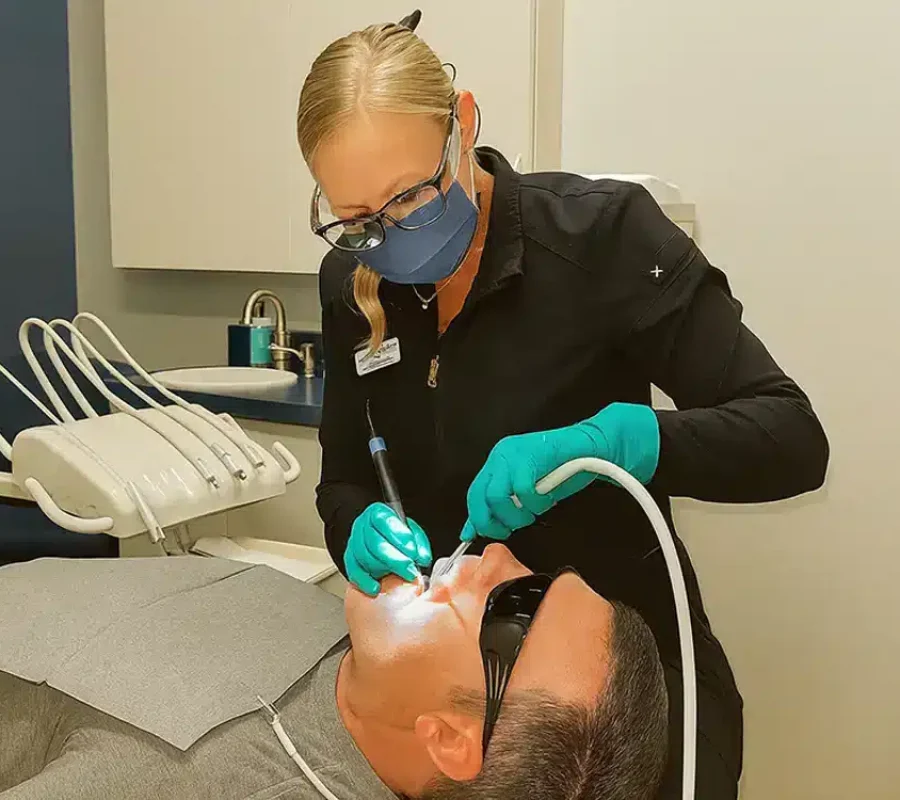 dentist performing a dental cleaning on a patient